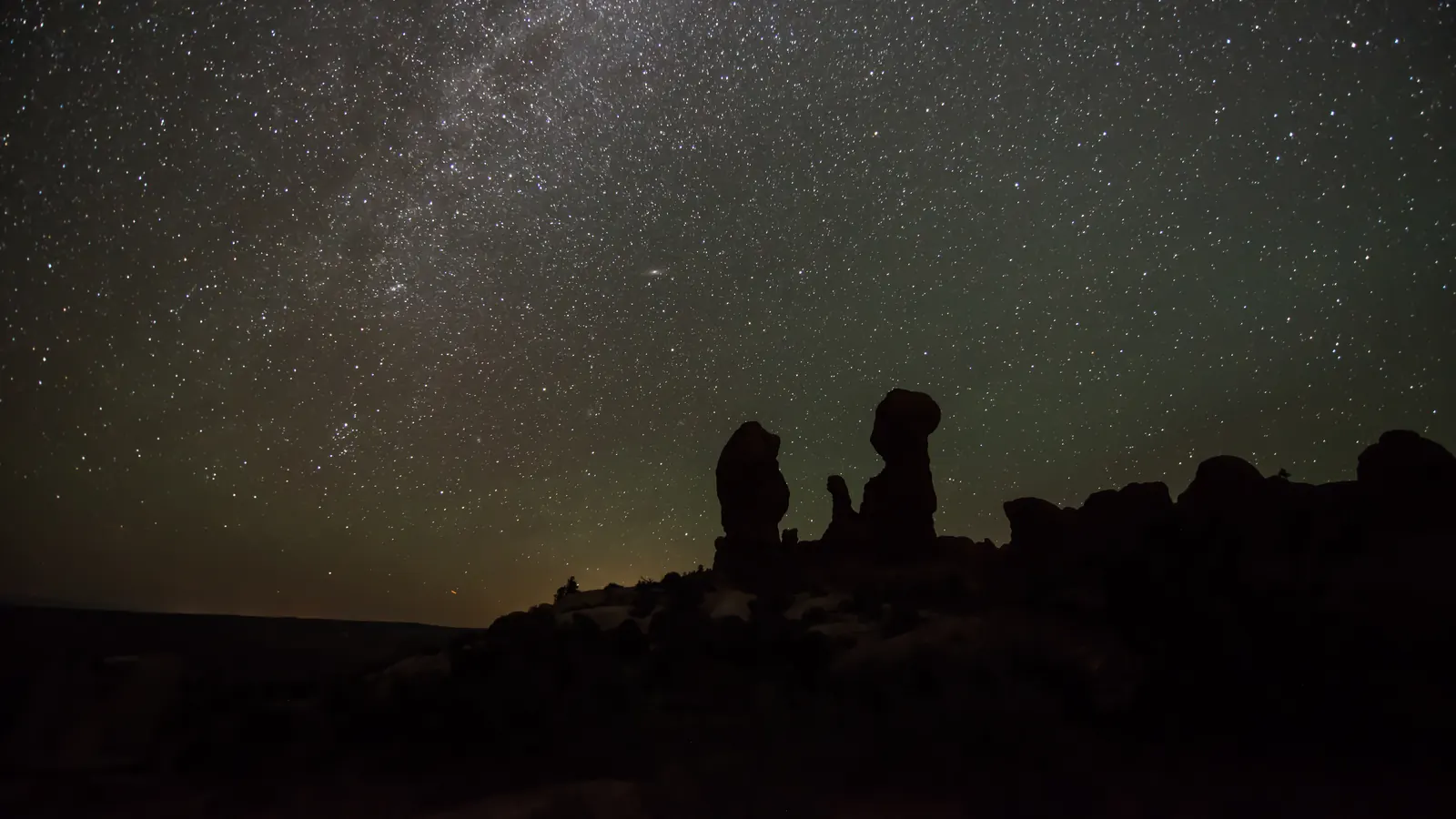 A wide, starry sky over rock hoodoos in Arches National Park, Utah