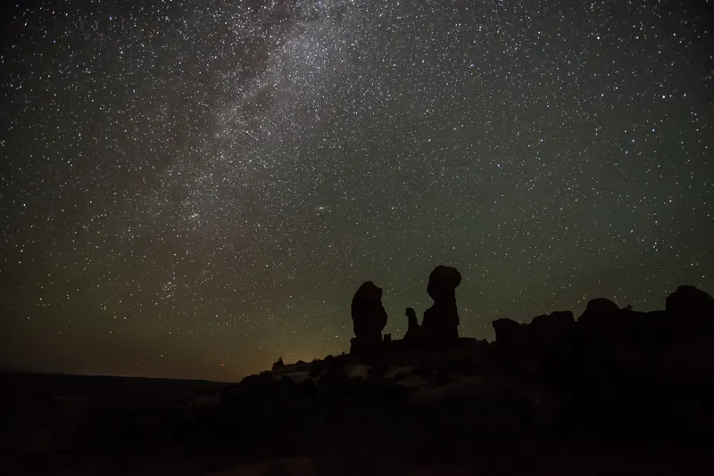 A wide, starry sky over rock hoodoos in Arches National Park, Utah